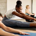 Individual stretching to relieve pain in a yoga class.